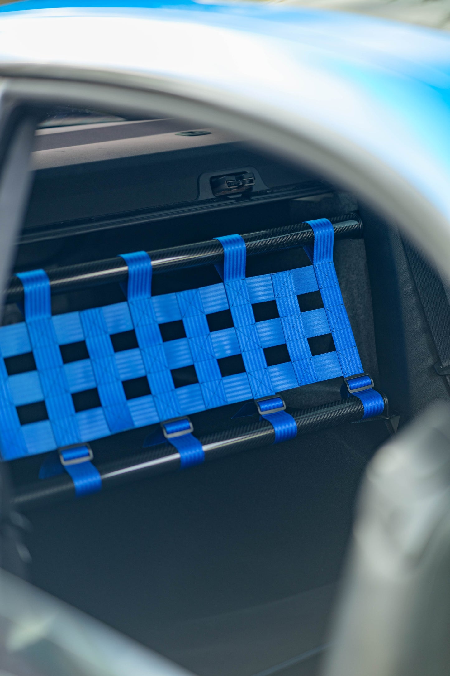 Clubsport-Set für BMW 3 E92 mit Carbon-Strebe und Netz, montiert anstelle der Rücksitzbank für Gewichtsreduzierung und klare Innenraum-Trennung. Ansicht: Beifahrerseite.